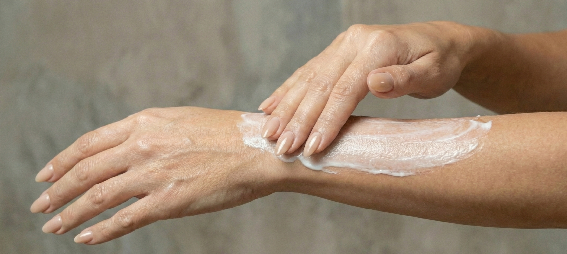 Hand that is moisturizing an arm with body lotion
